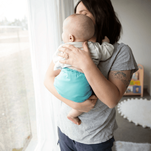 image of a baby wearing a thirsties award-winning duo wrap cloth diaper cover in lagoon