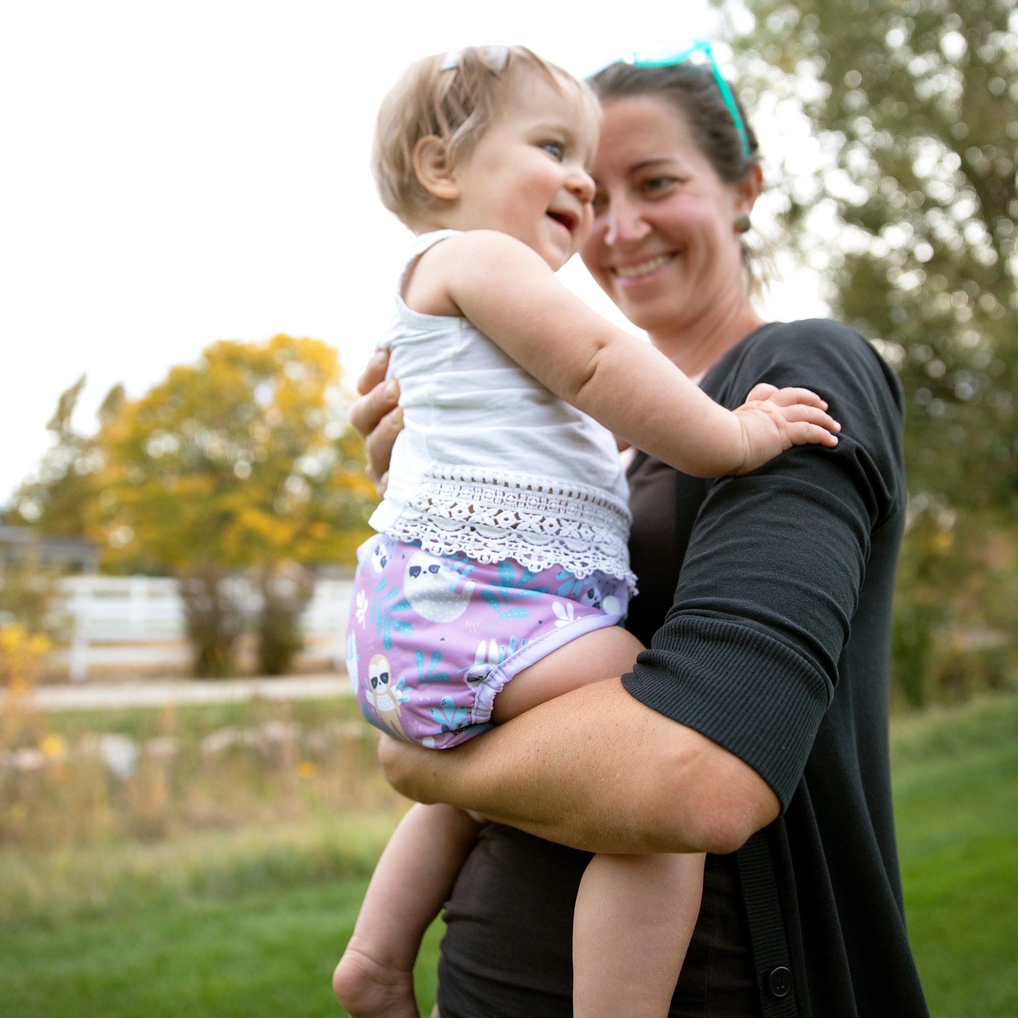 Image of a mom with her baby who is wearing a Thirsties Pocket Diaper in Sloth Life Print