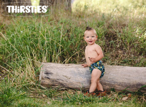 image of baby outside by a log