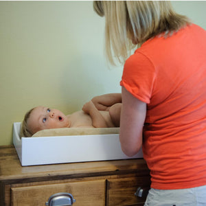 image of woman changing baby on a table