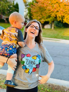 Laughing woman holding baby outside