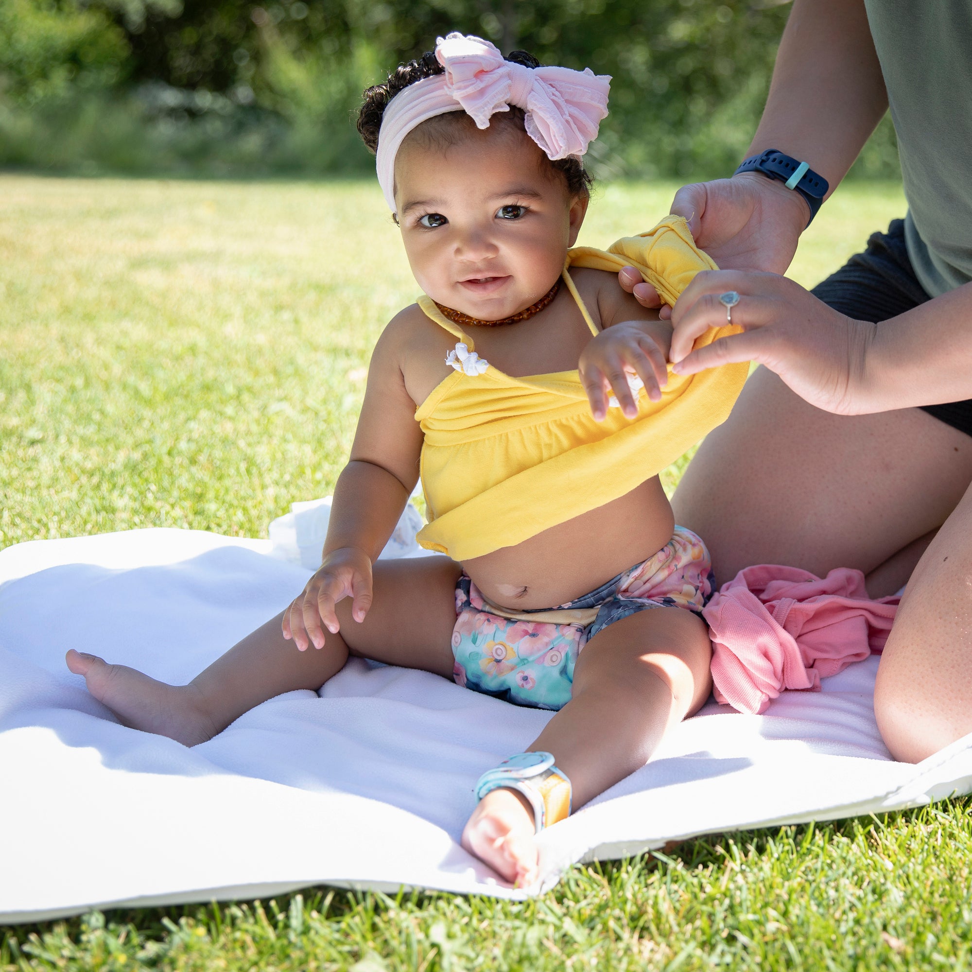 Image of baby wearing a thirsties all in one in poppy