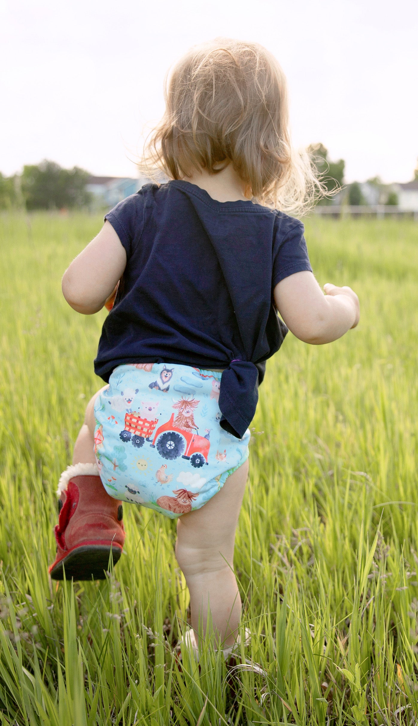 Image of baby wearing a Thirsties One Size Pocket Diaper in Ferm-stockin