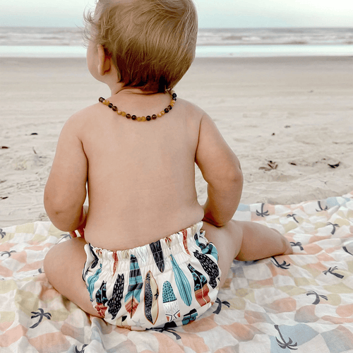 image of a baby wearing a thirsties reusable swim diaper in cowabunga