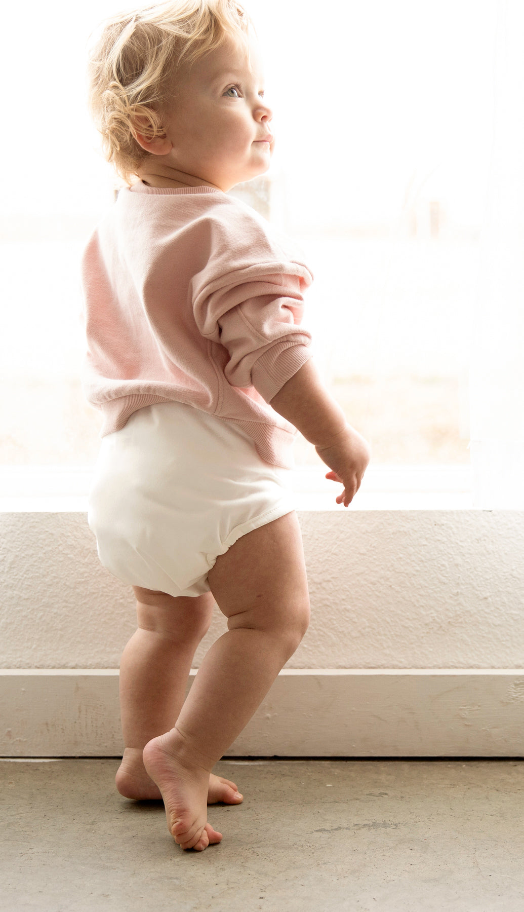 Image of a baby wearing a Thirsties Baby Cloth Diaper Cover in Birch on top of a Duo Fitted Cloth Diaper