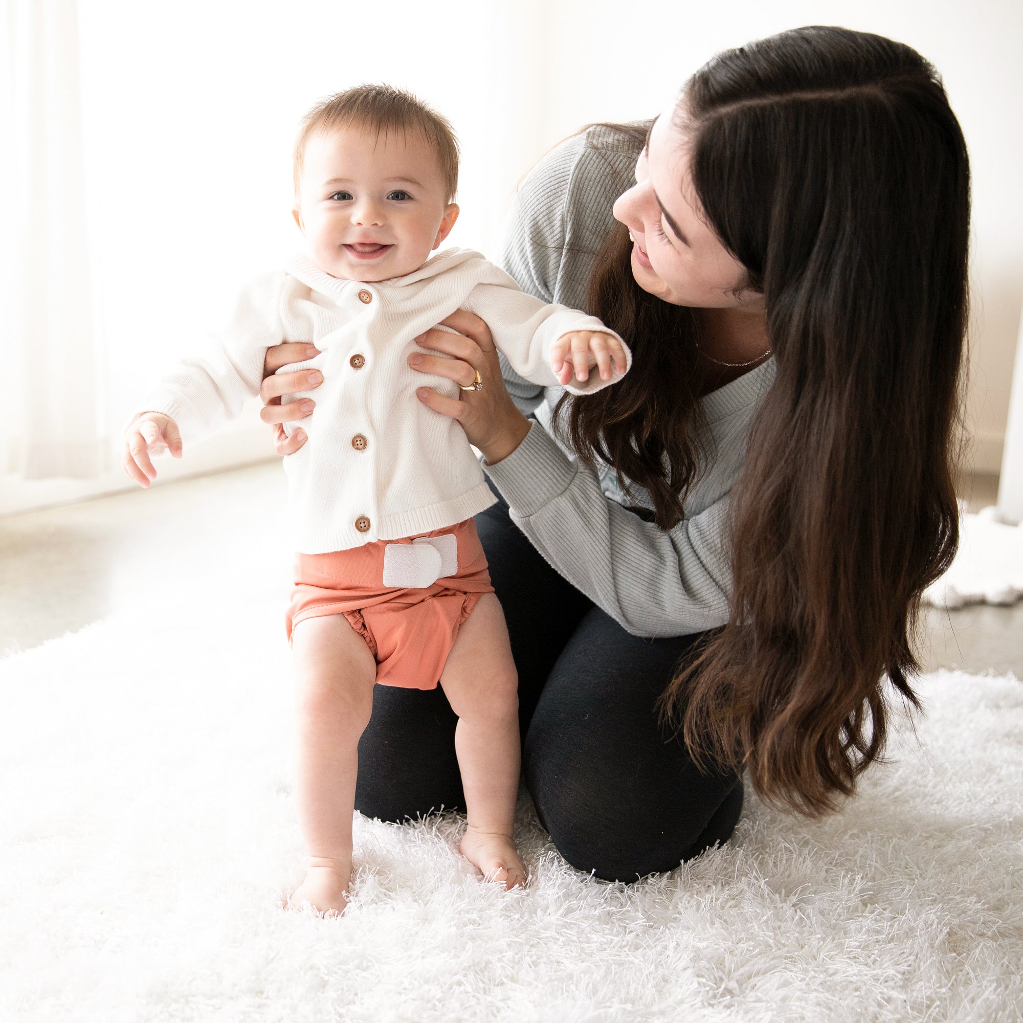 Image of a mom and her baby wearing a Thirsties Duo Wrap with hook and loop closures in Clay