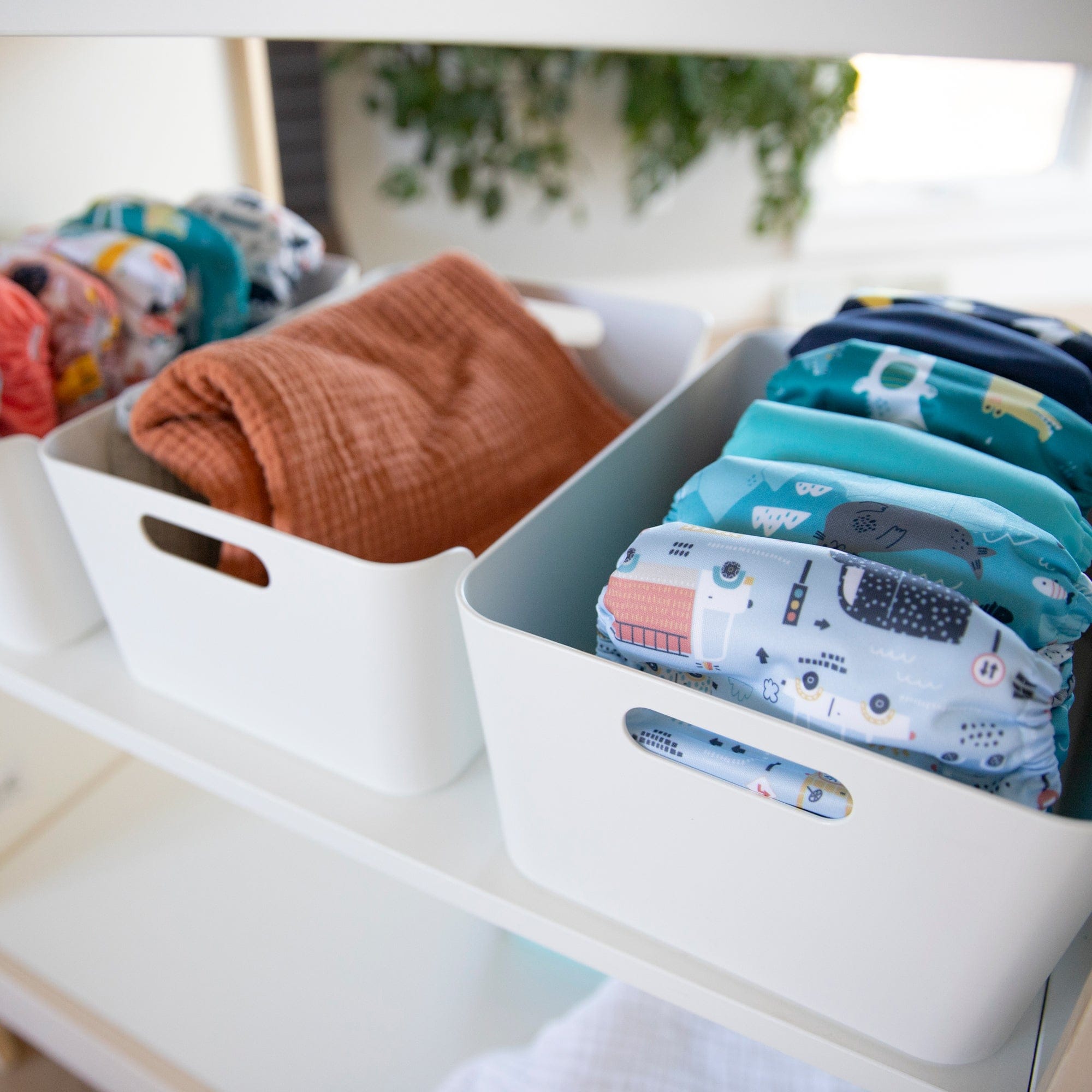 Thirsties cloth diapers stacked in white bins