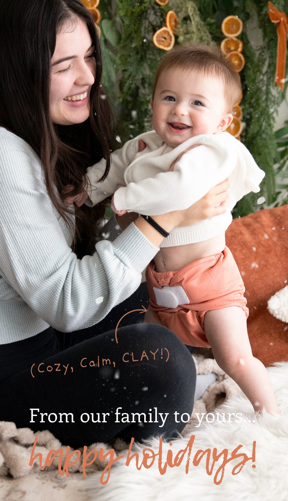 Image of mom with her infant showing off his Thirsties Baby Duo Wrap in Clay with hook and loop closures.