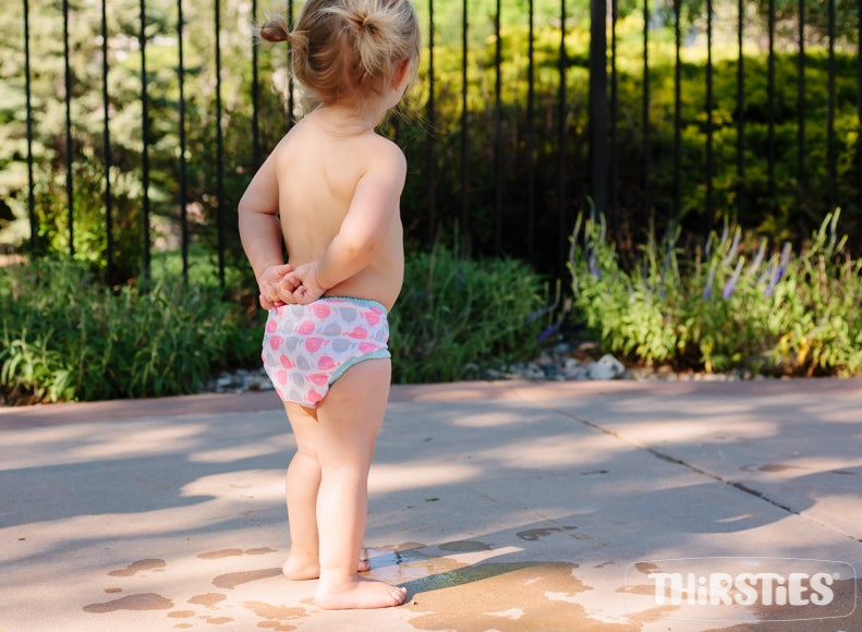 -Image of baby wearing Thirsties swim diaper standing outside